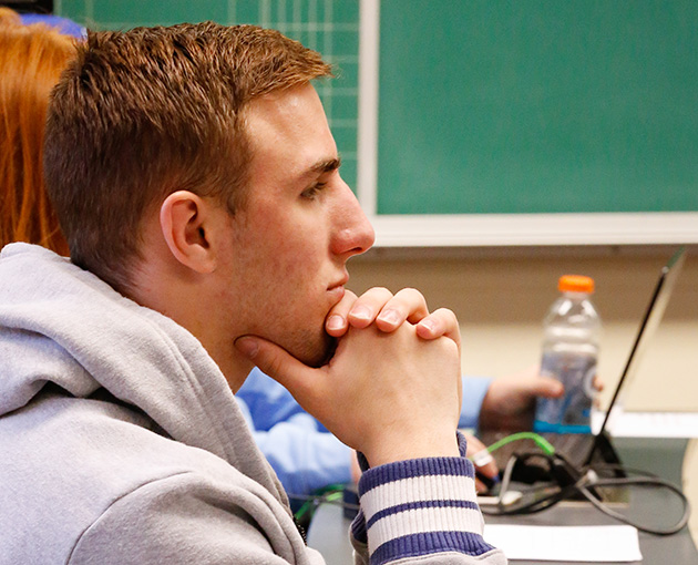 Male student with hands under chin