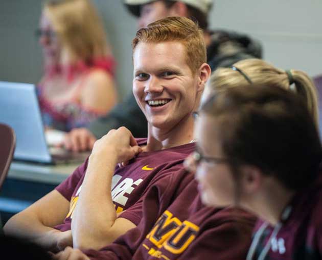 A student in a Wolves shirt smiles