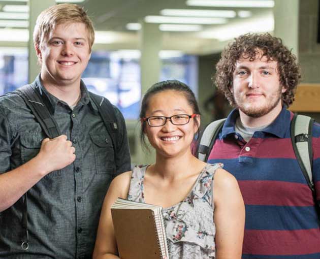 Three students smile