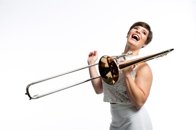 Laughing female musician holding trombone