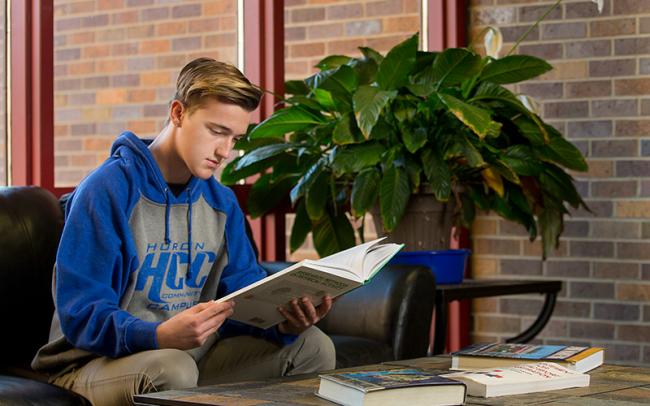 Male student looking at paperwork at Huron Community Campus